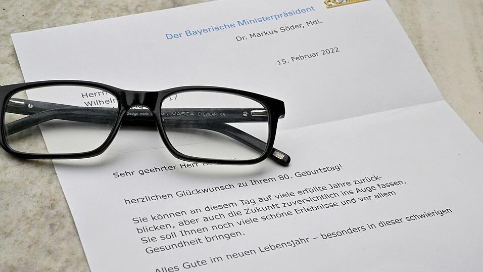 Glückwunschschreiben des bayerischen Ministerpräsidenten zum 80. Geburtstag liegt auf einem Tisch. Glückwunschschreiben des bayerischen Ministerpräsidenten zum 80. Geburtstag liegt auf einem Tisch.