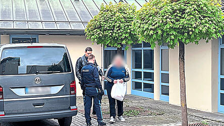Die Beschuldigte wird von Polizeibeamten ins Landgericht gebracht.
