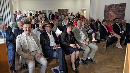 Schon kurz vor Beginn der Vernissage ein vollbesetzter Saal. Vorne (v.l.) die Festredner Bürgermeister Markus Hofmann, Kurator Leo Schötz, Kulturreferentin Dr. Bärbel Kleindorfer-Marx und Schirmherr Julian Preidl.