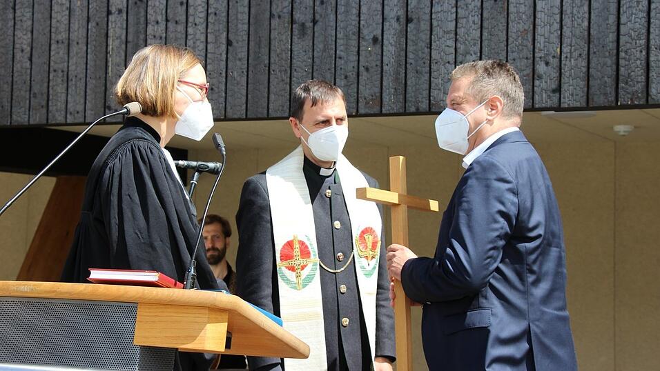 Pfarrerin Marjaana Marttunen-Wagner und Domkapitular Thomas Pinzer segneten übergrbaen Martin Neumeyer ein Kreuz.
