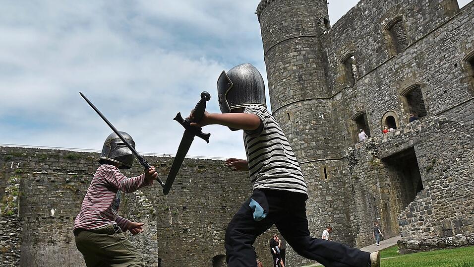 Kleine Ritter kämpfen in der großen Burg: Philipp und Finn üben sich im Schwertkampf auf Harlech Castle in Gwynedd. Kleine Ritter kämpfen in der großen Burg: Philipp und Finn üben sich im Schwertkampf auf Harlech Castle in Gwynedd.