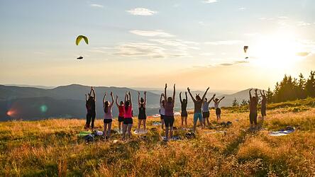 „Sundown Yoga“ im magischen Licht des Sonnenuntergangs auf der Osserwiese wurde durch die Gleitschirmflieger darüber ein einzigartiges Erlebnis. „Sundown Yoga“ im magischen Licht des Sonnenuntergangs auf der Osserwiese wurde durch die Gleitschirmflieger darüber ein einzigartiges Erlebnis.