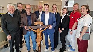 Franz Amberger (Dritter von links) &uuml;bergibt an B&uuml;rgermeister Franz Kopp (F&uuml;nfter von links) ein stattliches Holzkreuz, das seinen Platz in der Tagespflege finden soll. &Uuml;ber die Geste freuen sich nicht nur Pfarrer Kilian Limbrunner (Zweiter von links), BRK-Kreisvorsitzender Theo Zellner (links) und BRK-Kreisgesch&auml;ftsf&uuml;hrer Manfred Aschenbrenner. Auch Yvonne Lautenschlager (Dritte von rechts), Leiterin der Ambulanten Dienste, sowie Einrichtungsleiterin Sandra Fr&uuml;chtl (Vierte von rechts) und die BRK-Mitarbeiterinnen Michaela Huber (rechts) und Regina Klein sind angetan von dem besonderen Geschenk zur Segnung.