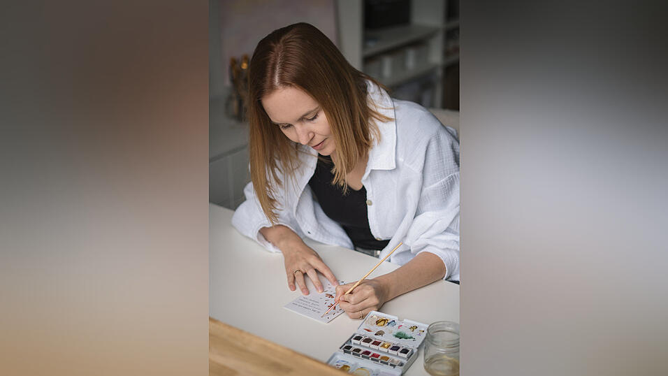 Lisa Dorner an ihrem Schreibtisch: Beim Gestalten von Gl&uuml;ckwunschkarten kann sie sich entspannen.
