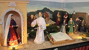 In der ersten Krippenszene ist die Verkündigung des Herrn dargestellt; daneben aufgeschlagen die Stelle im Evangelium.