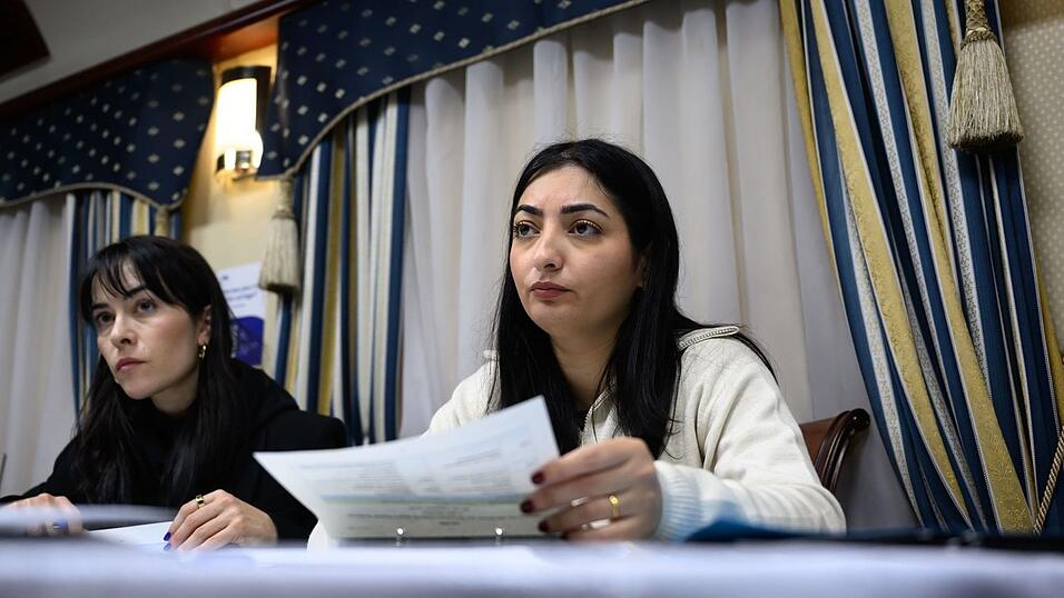 Reem Alabali Radovan (SPD, r), Bundesministerin für wirtschaftliche Zusammenarbeit und Entwicklung, und Pressesprecherin Aline Abboud besprechen im Zug nach Kiew das Reiseprogramm.