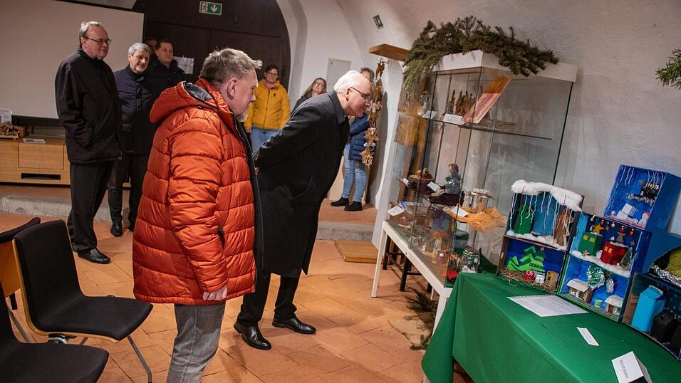 Bischof Rudolf Voderholzer schaut sich die Krippen an.