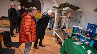 Bischof Rudolf Voderholzer schaut sich die Krippen an.