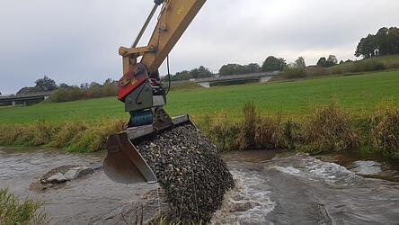 Ein Bagger kommt zum Einsatz, um den Kies zu waschen.