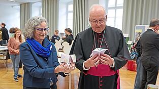 Ulrike Nübler und Bischof Rudolf Voderholzer mit einem „Weihnachts-Himmel-und-Hölle“ Spiel.