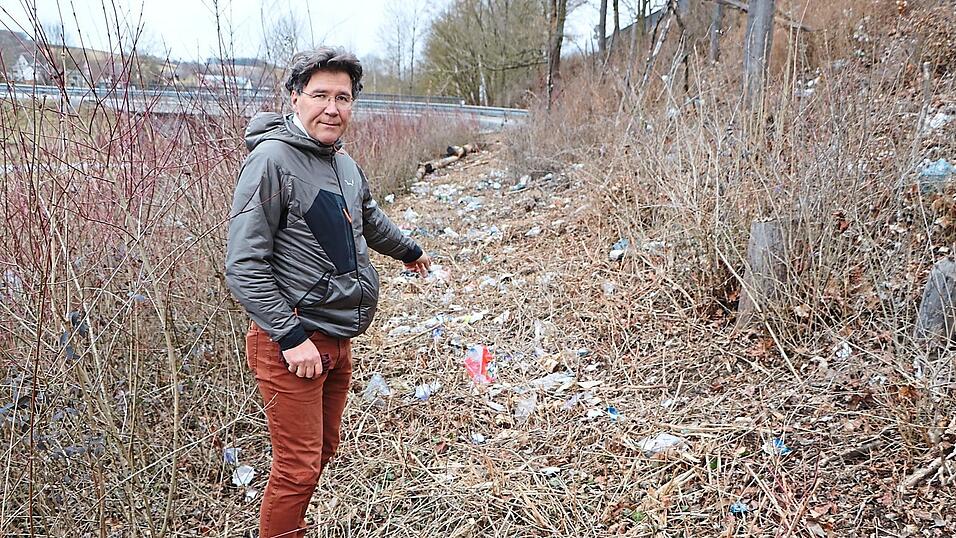 Bund-Naturschutz-Kreisvorsitzender Raimund Schoberer zeigt die Schneise, die das Mulchgerät entlang der Westseite der Böschung geschlagen hat.