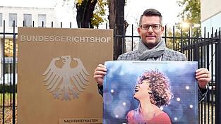 Tourneeveranstalter Oliver Forster vor dem Bundesgerichtshof (BGH) mit Plakat der Show 'Simply The Best - Die Tina Turner Story'.
