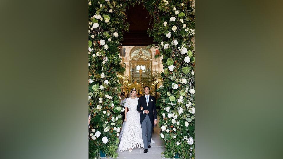 Das Brautpaar eingerahmt von weißen Blumenschmuck. Das Brautpaar eingerahmt von weißen Blumenschmuck.