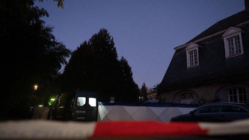 Ein Polizeiauto und Sichtschutz stehen auf dem Gelände der Heidelberger Universität am Tatort eines Amoklaufes.