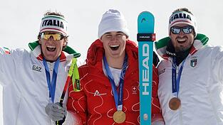 Olympiasieger Franjo von Allmen wird flankiert von Silber-Gewinner Giovanni Franzoni (links) und dem Drittplatzierten Dominik Paris.