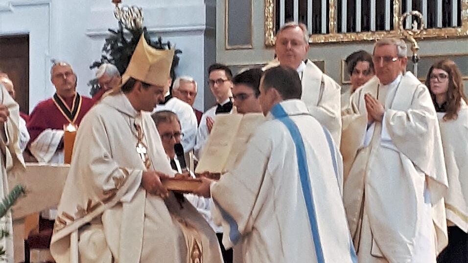 Matthias Zellner kniet nach der Weihe vor dem Bischof. Matthias Zellner kniet nach der Weihe vor dem Bischof.