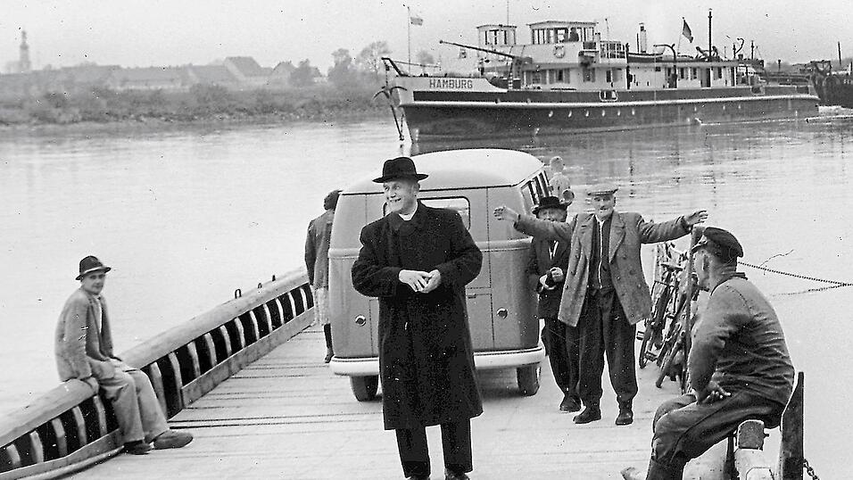 Ein Laden im Auto f&auml;hrt auf einer F&auml;hre &uuml;ber die Donau: die Donauf&auml;hre mit dem fahrbaren B&auml;ckerladen auf dem Weg nach Illkofen. Auf dem Bild Pfarrer Georg Fleischmann (Illkofen) und links, sitzend, Karl Bierschneider senior.