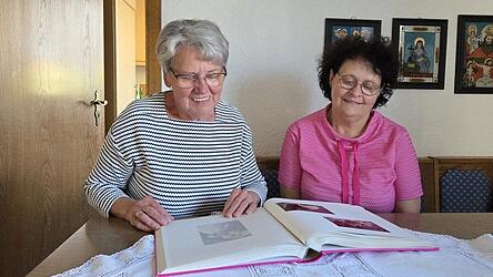 Seiten voll sch&ouml;ner Erinnerungen: Apollonia Englmeier und Tochter Christine Weindl bl&auml;ttern ein Fotoalbum mit Pfingstfotos durch.