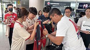 Der frühere Bayern-Profi Giovane Elber gibt Autogramme (vorne r) am Flughafen. Der frühere Bayern-Profi Giovane Elber gibt Autogramme (vorne r) am Flughafen.