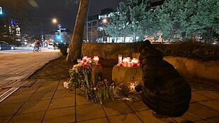 Eine Frau legt Blumen in der Münchner Innenstadt in der Nähe des Stiglmaierplatzes nieder, wo ein Auto in einen Demonstrationszug gefahren ist. Mehrere Menschen wurden zum Teil schwerst verletzt. (Archivbild)