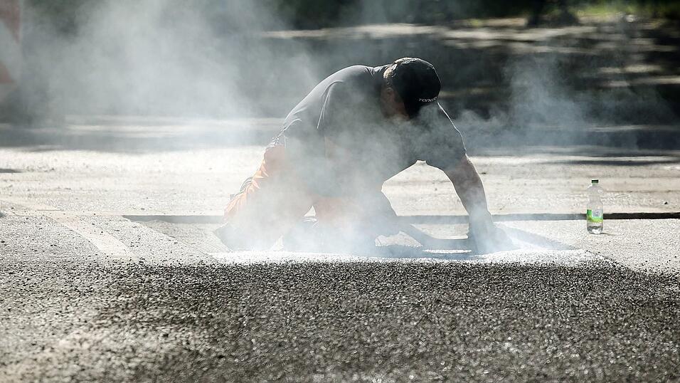 Ein Bauarbeiter repariert eine Stra&szlig;e in Berlin mit Bitumen, einem Bindemittel f&uuml;r Asphalt. (Symbolbild)
