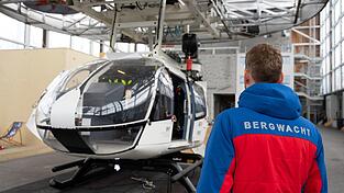 Im Bergwacht-Zentrum für Sicherheit und Ausbildung steht ein Mitglied der Bergwacht Bayern vor einem Hubschrauber-Modell. (Archivbild)