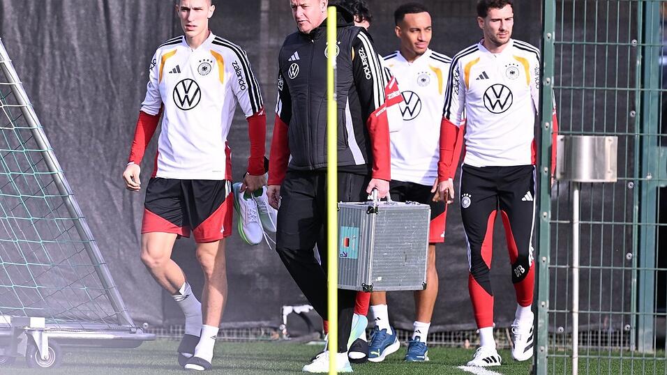 Mit Teamarzt Hahne (2.v.l.) betritt Schlotterbeck (l.) den Trainingsplatz. Mit Teamarzt Hahne (2.v.l.) betritt Schlotterbeck (l.) den Trainingsplatz.