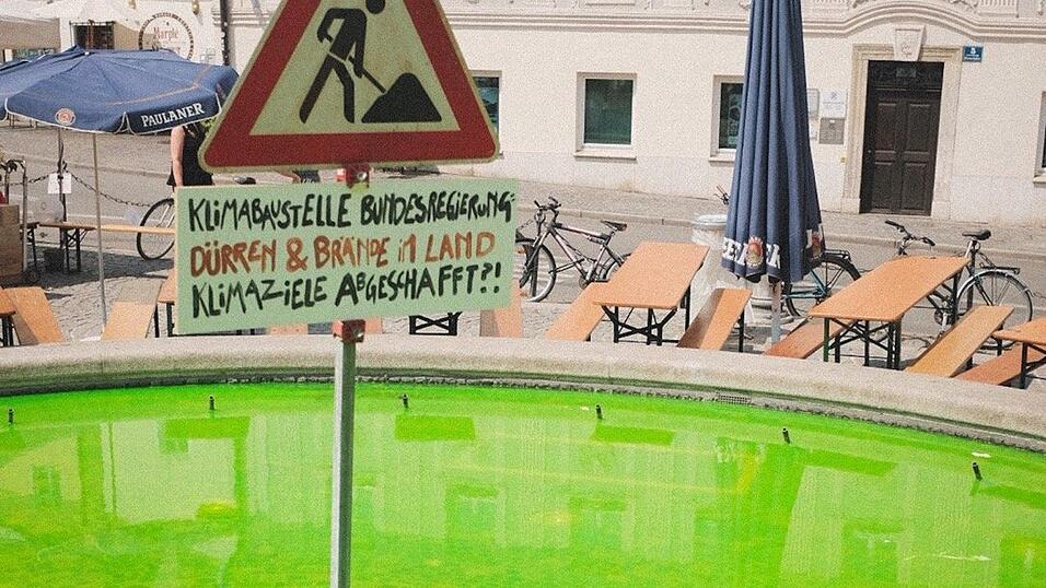 Der von einer End Fossil Occupy-Aktivistin mit Uranin grün gefärbte Brunnen auf dem Regensburger Bismarkplatz im Juni 2023. Der von einer End Fossil Occupy-Aktivistin mit Uranin grün gefärbte Brunnen auf dem Regensburger Bismarkplatz im Juni 2023.