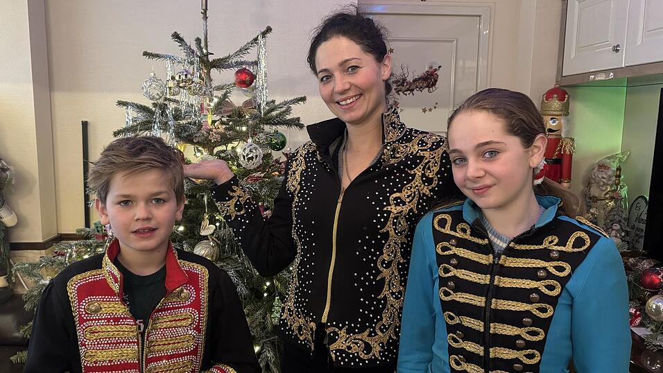 Angelina Spindler mit ihren Kindern Alessandro und Dylain vor dem geschm&uuml;ckten Christbaum in ihrem Wohnwagen.