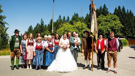 Das Brautpaar Franziska und Johannes Meindl mit ihrer kleinen Tochter Emilia und den Vertretern des Trachtenvereins Stoarieda Ottenzell