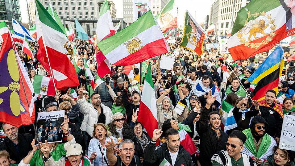 Menschen jubeln auf einer Iran-Demonstration am Potsdamer Platz, nachdem auf der B&uuml;hne der angebliche Tod von Staatsoberhaupt Chamenei verk&uuml;ndet wurde.
