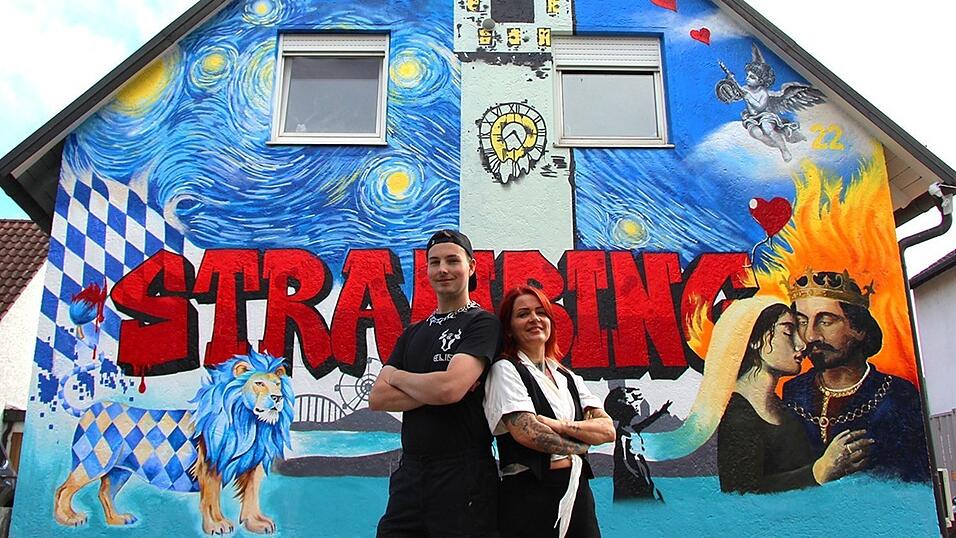 Sina Frohnholzer gemeinsam mit Vergoldermeister und Graffitikünstler Elias Oberländer vor der Hausfassade in der Aitrachstraße.