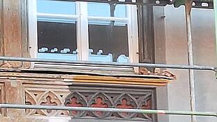 Drei verschiedene Grautöne und ein tiefes Rot betonen die architektonischen Details der Fassade. Drei verschiedene Grautöne und ein tiefes Rot betonen die architektonischen Details der Fassade.