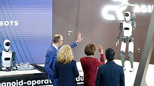 Bundeskanzler Friedrich Merz winkt einem Roboter zu &ndash; die Zukunft winkt zur&uuml;ck.