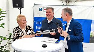 Beatrix Kramlinger (links) und Mario Müller (rechts) von der Unternehmensgruppe Stoffel übergeben Staatsminister Christian Bernreiter die Zeitkapsel.