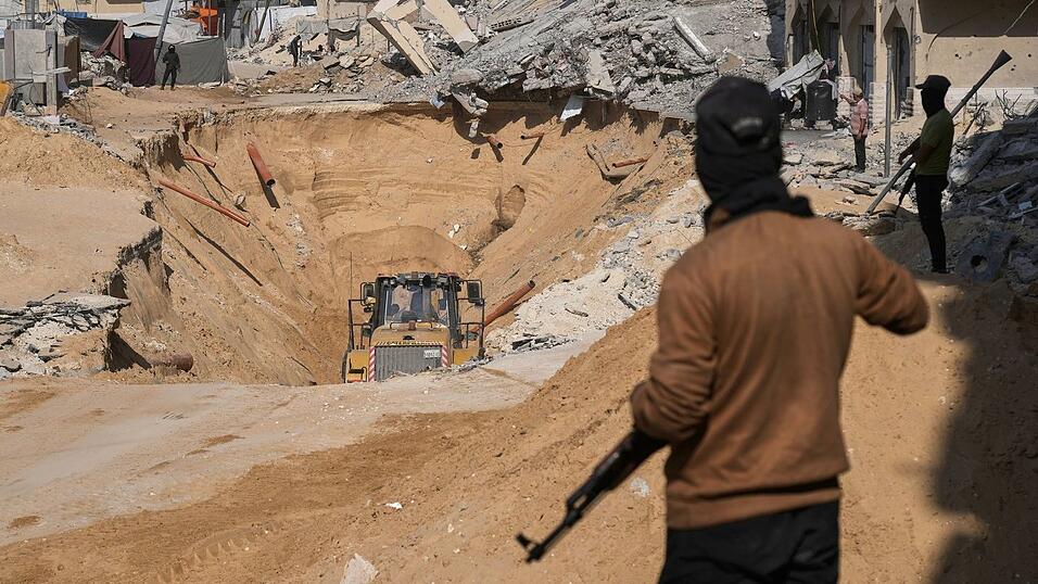 Mitglieder der islamistischen Hamas suchen nach Leichen israelischer Geiseln.