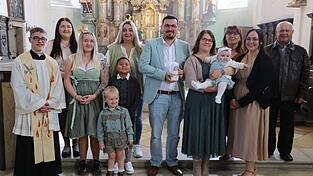 Die Taufgemeinschaft zusammen mit dem Täufling Emilia Maria Pöllmann auf dem Arm ihrer Patin Sophia Dobmeier, den Eltern und Kaplan Michael Steinhilber