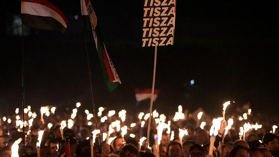 Anh&auml;nger von Peter Magyar, dem Vorsitzenden der oppositionellen Tisza-Partei, halten bei der Wahlkampfveranstaltung ihre beleuchteten Handys hoch.