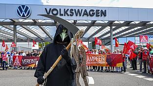 Der Sensenmann steht vor dem VW-Werk in Zwickau: Das einstige Schaufenster für Elektromobilität steht plötzlich im Fokus der Spardebatte. Der Sensenmann steht vor dem VW-Werk in Zwickau: Das einstige Schaufenster für Elektromobilität steht plötzlich im Fokus der Spardebatte.