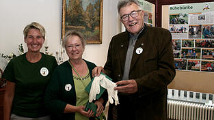 August Groh bekam von Brigitte Murla (Mitte) im Beisen von der zweiten Vorsitzenden Rosi Neumeier (l.) Korn, eine Spende und zwei linke Arbeitshandschuhe &uuml;berreicht.