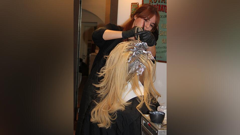 Friseur-Meisterin Bettina Schreiner trägt bei einer Kundin Folien-Strähnen auf. Wer sich seine Haare beim Profi färben oder tönen lässt, ist auf der sicheren Seite. (Foto: Rothmeier)