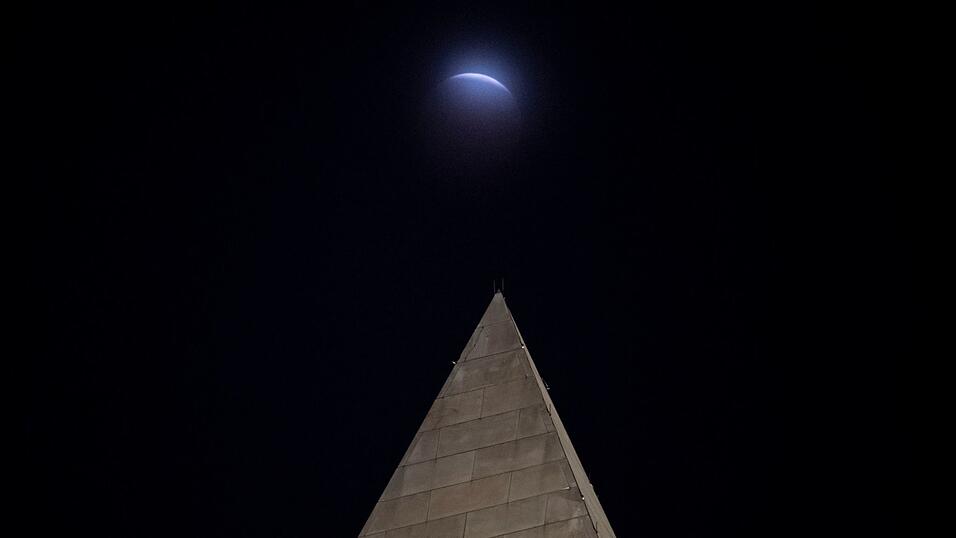 Hinter dem Washington-Monument in Washington ist die partielle Mondfinsternis durch die Wolken zu sehen. Hinter dem Washington-Monument in Washington ist die partielle Mondfinsternis durch die Wolken zu sehen.