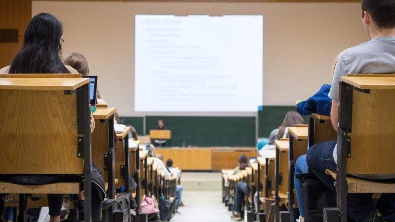 Studentinnen und Studenten sitzen während einer Vorlesung in einem Hörsaal. Studentinnen und Studenten sitzen während einer Vorlesung in einem Hörsaal.