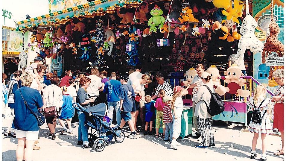 Gro&szlig;er Andrang am Losstand, wo es f&uuml;r vier Mark zehn Lose gab. Man beachte das Schild zwischen den baumelnden Pl&uuml;schraubkatzen am rechten Bildrand: &bdquo;Leute zum Mitreisen gesucht&ldquo; - ein lange Zeit typisches Stellengesuch der Branche.