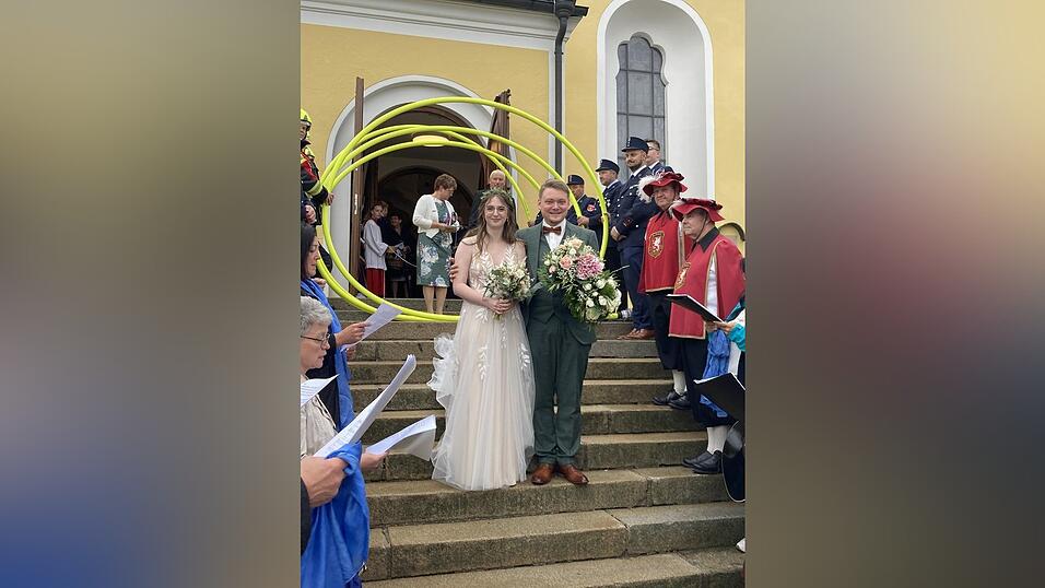 Nach dem Gottesdienst erwartete das Brautpaar ein langes Spalier bestehend aus Feuerwehr, Spielmannszug und Chor.