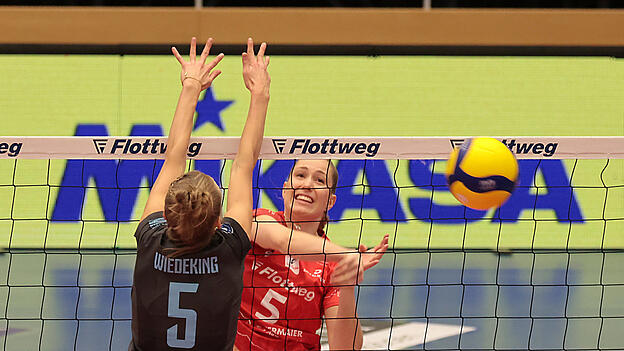 Mit Freude bei der Arbeit: Nadine Burbrink (rotes Leiberl) haut die B&auml;lle gerne mit Schmackes am Block vorbei. Die Vilsbiburgerin packt auch bei gegnerischen Angriffen am Netz kr&auml;ftig zu und punktet in sch&ouml;ner Regelm&auml;&szlig;igkeit sogar zweistellig.