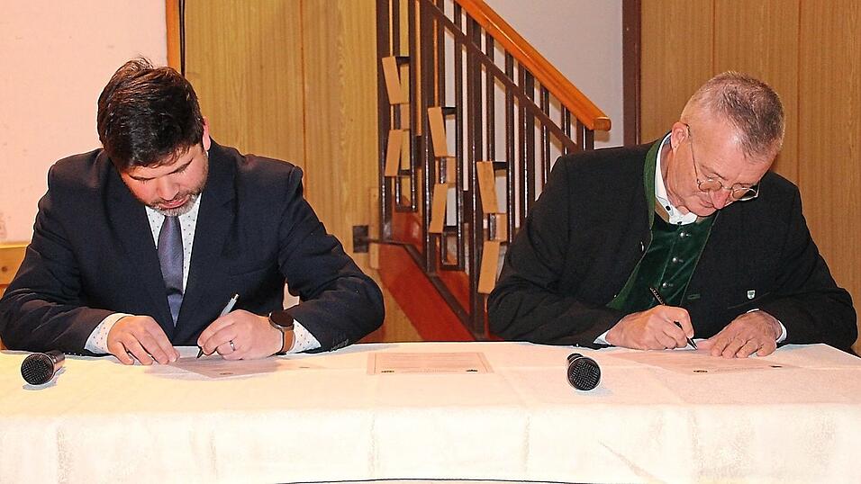 Die beiden B&uuml;rgermeister Jan Bozděch (links) und Markus Ackermann unterzeichnen die Partnerschaftsurkunden.
