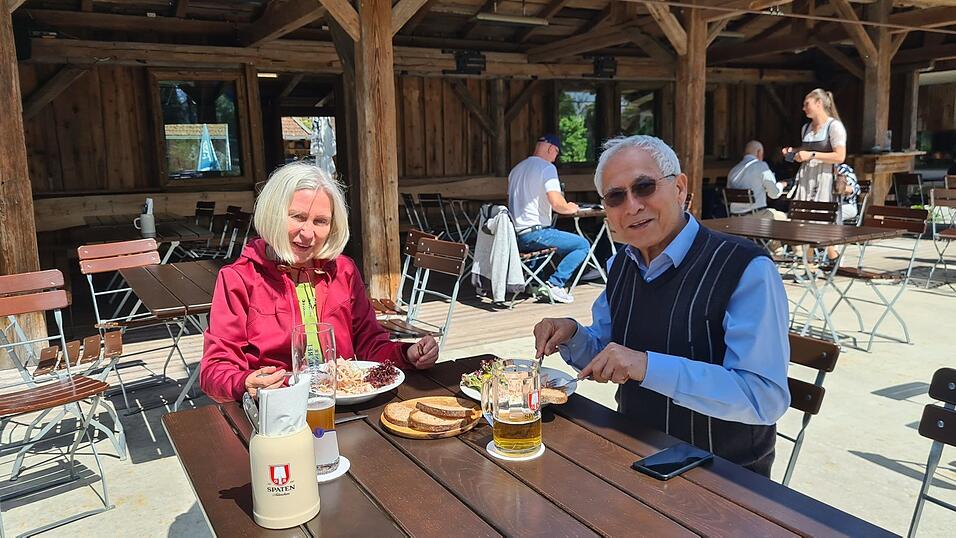 Zwei Urlauber genie&szlig;en Wurstsalat in der Wasserwirtschaft.