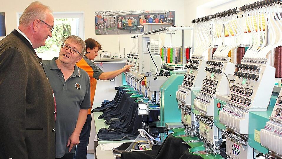 Firmenchef Christian Tischler f&uuml;hrt Landrat Franz L&ouml;ffler durch seinen Stickerei-Betrieb.