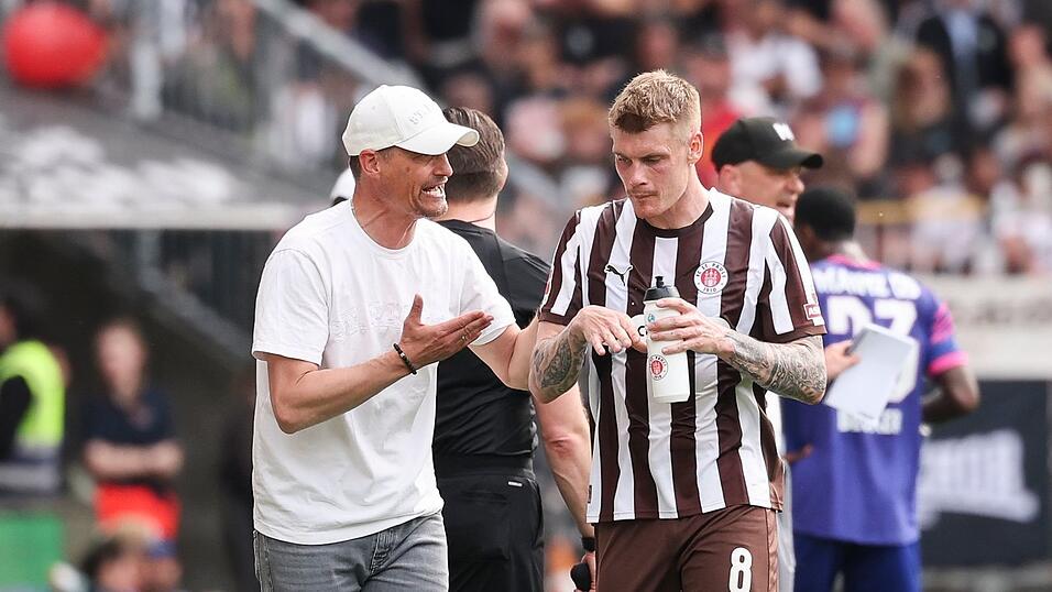 St. Paulis Trainer Alexander Blessin (l) spricht mit Eric Smith.